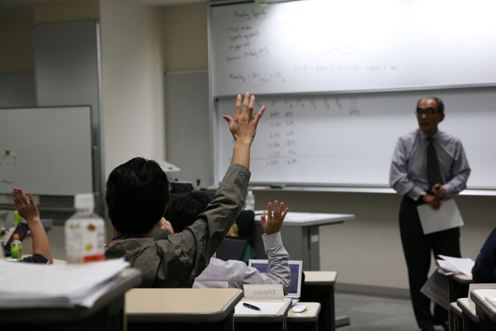 Student raising hand in university class